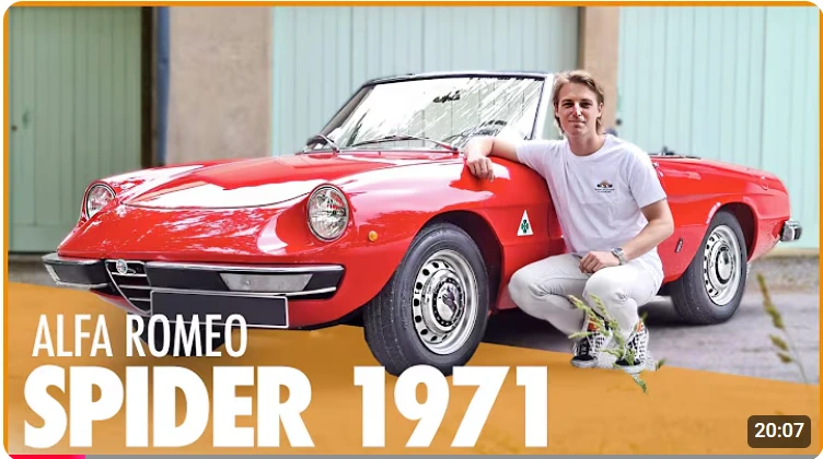 Man posing next to a bright red Alfa Romeo Spider 1971 classic convertible.
